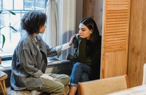 A woman comforting her friend, who appears to be having a hard time