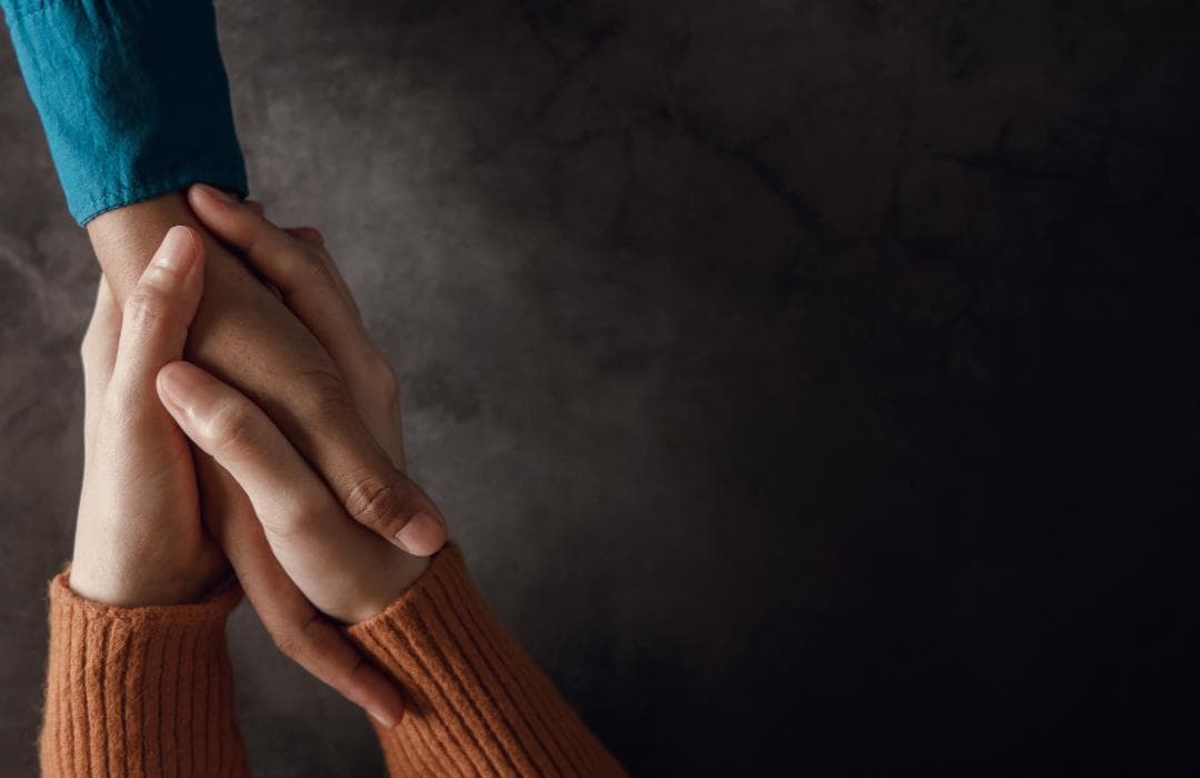 A set of hands empathically holding a third